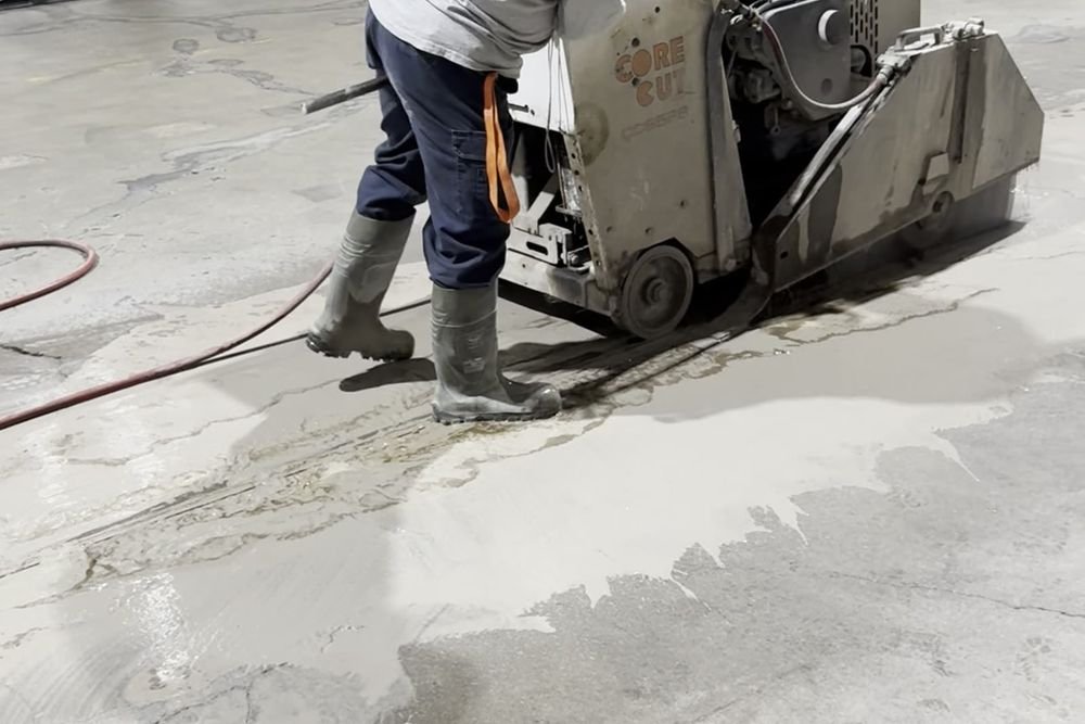 Une scie de plancher avance dans une dalle de béton